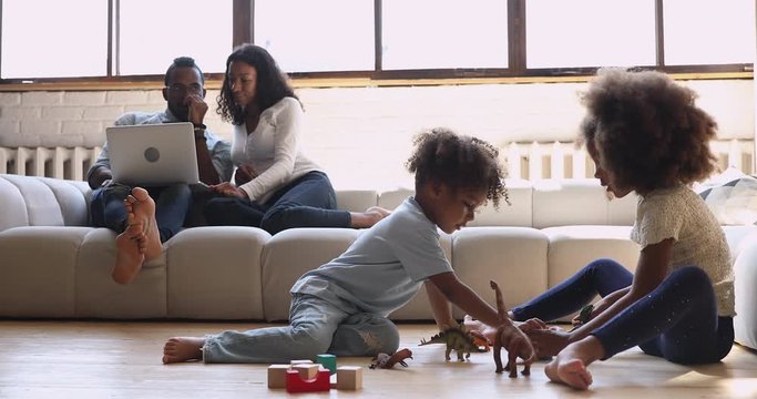 African american parents with kids relaxing in living room