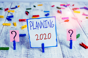 Conceptual hand writing showing Planning 2020. Concept meaning Begin with end in the Mind Positioning Long term Objectives Crumbling sheet with paper clips placed on the wooden table