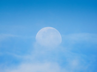 view morning of full moon 70% falling around with white clouds and blue sky background.