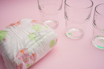 Baby diapers with liquid absorbance on pink background