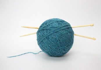 Blue wool and knitting needleson