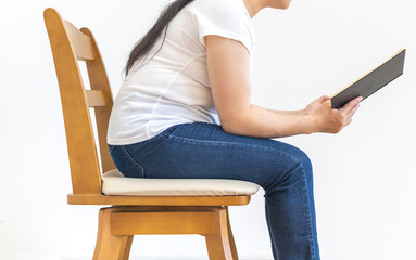 椅子に座って本を読んでいる少し太った女性