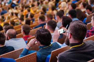 Business conference attendees sit and listen