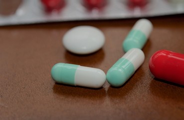 Medication capsules in macro view and dark brown background