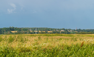 View of endless rural fields. A thunderstorm is approaching. Rural landscape in the summer.