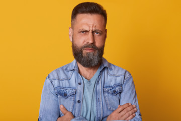 Close up portrait of fashionable middle aged man with beard and trendy haircut wearing denim...