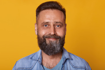 Portrait of single bearded handsome young Caucasian man with cute smile,male wearing denim jacket,...