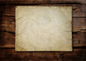 Vintage old grungy paper banner over ancient wood background