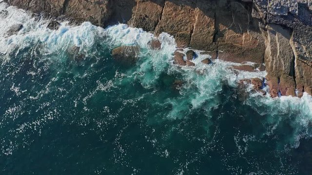 Travelling shot over sea waves breaking in the reefs and coast, Cantabrian sea, Spain - drone aerial view