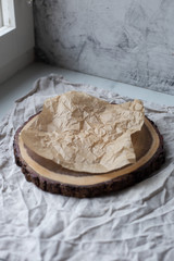 Crumpled piece of brown paper sheet on wooden backgroun