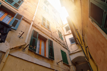 View of old close yellow courtyard with green wooden window shutters in Riomaggiore, Cinque Terre, Liguria, Italy