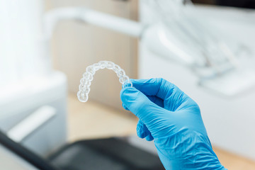 Doctor hand holding a clear dental aligner