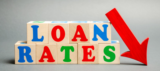 Wooden blocks with the word Loan rates and arrow down. The concept of low mortgage rates. Real...