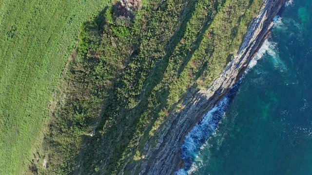Travelling shot over sea waves breaking in the reefs and coast, Cantabrian sea, Spain - drone aerial view