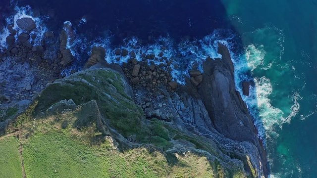 Travelling shot over sea waves breaking in the reefs and coast, Cantabrian sea, Spain - drone aerial view
