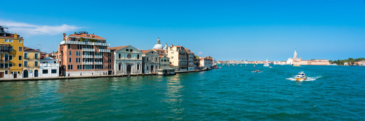 Fototapeta na wymiar Venice. Vacation in Italy. Panoramic view of Venice from the Grand Canal. Venetian old colorful buildings on blue sky background. Boat trip through the canals. Header. Banner.