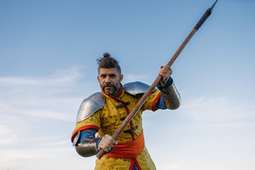 Old medieval knight in armor holds axe