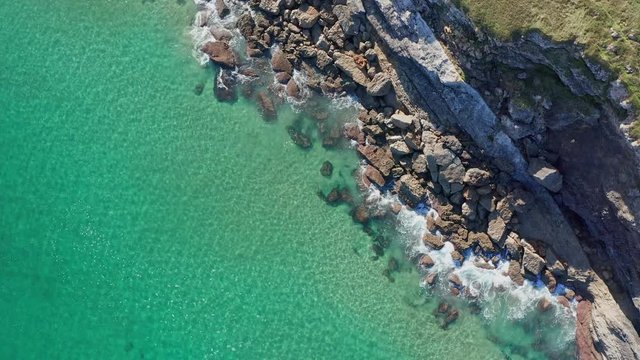 Emerald water sea waves breaking in the reefs and coast, Cantabrian sea, Spain - drone aerial view