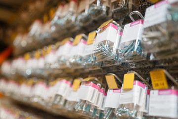 Rows of boxes with bolts in hardware store closeup