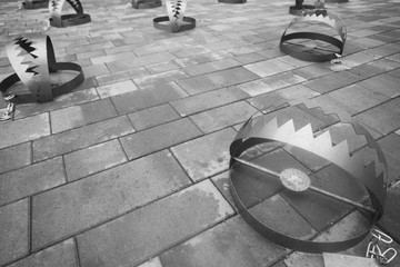 Human Rights, Multiple Victims concept. Metal bear traps on the city road. Text space. Monochrome...