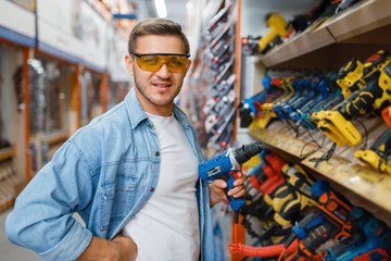 Buyer holding electric screwdriver, hardware store