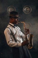 Fototapeta na wymiar Black jazzman plays the saxophone on stage