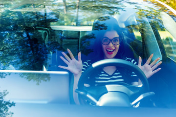 Woman in a self-driving autonomous electric vehicle with hands off the steering wheel