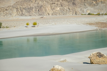 Clear water of Shyok River flowing along the sand beach in Ghanche. Gilgit Baltistan, Pakistan.