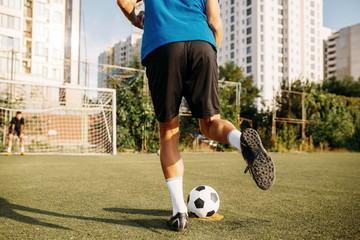 Male soccer player hits the ball on the field