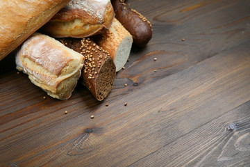 different bread baking with caraway seeds on a dark wooden background with copy space.