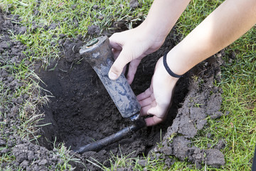 Bewässerungssystem im herbst wird mit 2 händen repariert