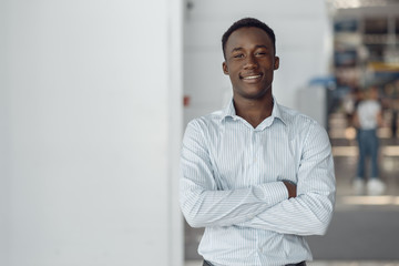 Black businessman poses in office building