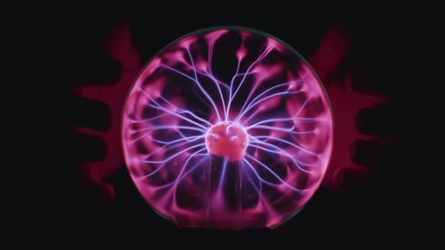 Magic Plasma Ball - a transparent sphere filled with inert gas and a high voltage electrode in center. Slowmotion of Hand held close to the energy discharges