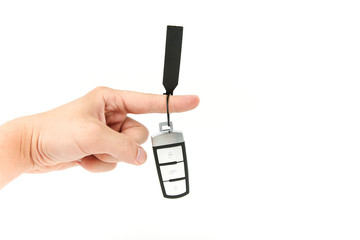 key chain from the new car hanging on the index finger of a man on a white background. the pointer direction with car keys on white background with copy space
