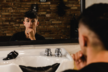 Young Handsome Barber Making Haircut Of teenager Man In Barbershop