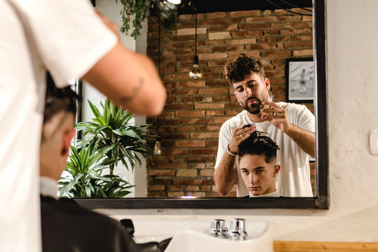 Teenager getting a modern haircut in a vintage barber shop