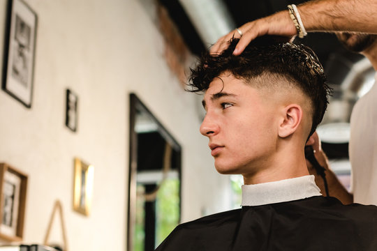 Teenager getting a modern haircut in a vintage barber shop