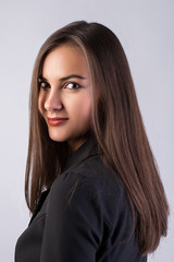 Naklejka premium business portrait of a young beautiful brunette girl in a jacket on a white background, straight dark hair, beautiful eyes, clean skin