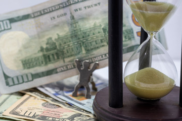 Competing against time. Race against time for productivity, money, success. Hourglass and money. Sand timer. carrying USD bills. selective focus. Man accomplished money gol conce © loren_zecena