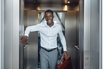 Black businessman goes into the elevator in office © Nomad_Soul