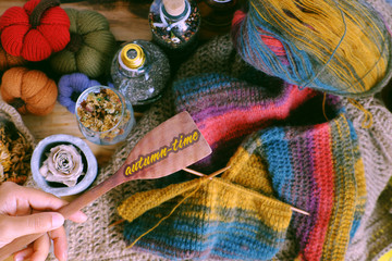 concept colorful autumn background, piece of wood, ornament table, pumpkin, knit scarf