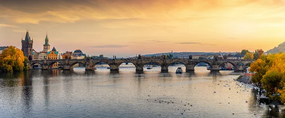 Selbstklebende Fototapeten Panorama der berühmten Karlsbrücke über die Moldau in Prag an einem Sonnenuntergang im Herbst © moofushi