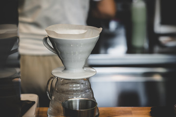 Closeup of coffee brewing gadget and filter paper on table