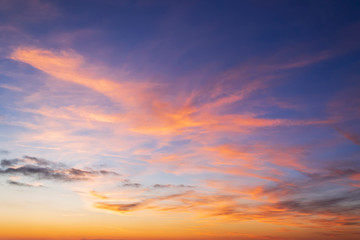 Beautiful orange clouds on a golden blue sky during sunset. Scenic sundown cloudscape for...