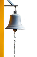 An old bell hang on yellow pole with white background. It can use for alarm or warning. It can use in many cases like fire alarm, classroom break, signal at train station and temple and others.