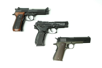 three pistols on a white background with copy space
