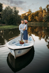 Fototapeta na wymiar Love couple standing in a boat on quiet lake