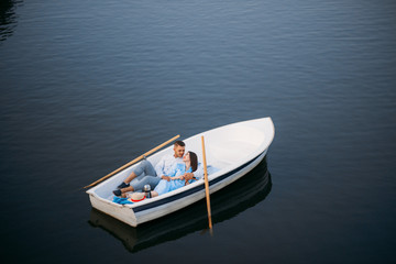 Fototapeta na wymiar Love couple lying in a boat on lake, top view