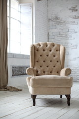 a large beige velvet chair in an empty room.