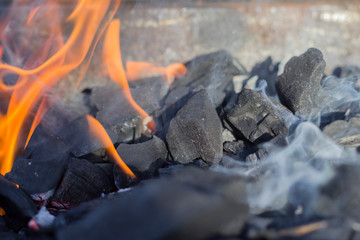 Burning charcoal with smoke and flame. Fire, grill concept. Close-up, copy space